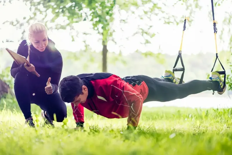 Trainer unterstützt einen Sportler beim Training im Freien